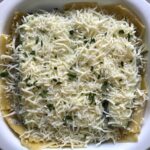 Shredded cheese and parsley on top of assembled White Lasagna Recipe with Zucchini and Ground Beef