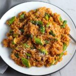 Asparagus and Tomato Quinoa Risotto with parmesan on top on a plate with fork.