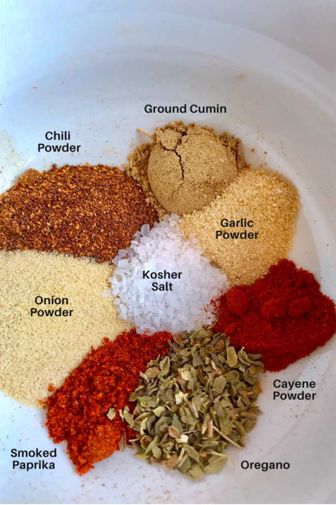 8 different spices separated in a bowl with labels. This is an easy recipe for Cajun Seasoning that's smokey, spicy, salty, peppery.