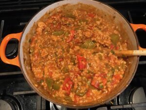 Pot of Tex Mex Unstuffed Peppers with Ground Chicken and cheese sprinkled on top op.  Juicy Sweet Bell Peppers are chopped up and cooked with the Tex Mex style ground chicken, tomatoes, Mexican seasonings, cheese, rice and corn tortillas.