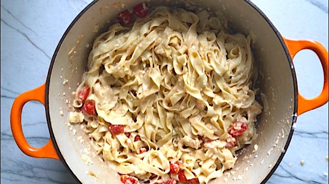 Fettuccine pasta mixed with creamy parmesan sauce and grape tomatoes for Creamy Pasta Primavera. It has fettuccine, parmesan cheese, roasted asparagus, carrots, tomatoes and fresh corn kernels.
