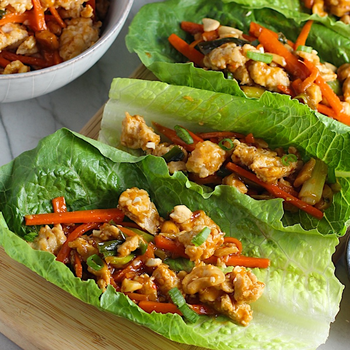 Close up of Low Carb Chicken Lettuce Wraps on wood platter.