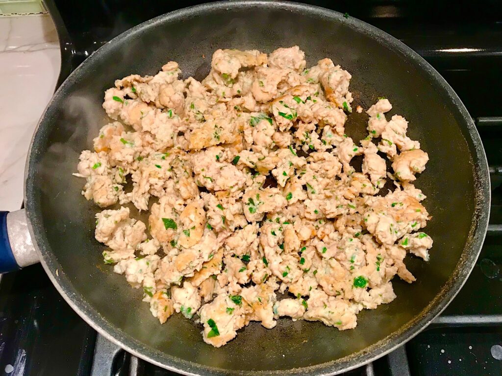 Ground Italian Chicken Sausage cooked in a frying pan..