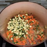 Carrots, celery, and zucchini cooking in pot for Puff Pastry Turkey Pot Pie. It's an easy dinner recipe to use leftover turkey from the holidays and ingredients you can have on hand! The vegetables and sauce come together so easily and store-bought puff pastry is a time saver.