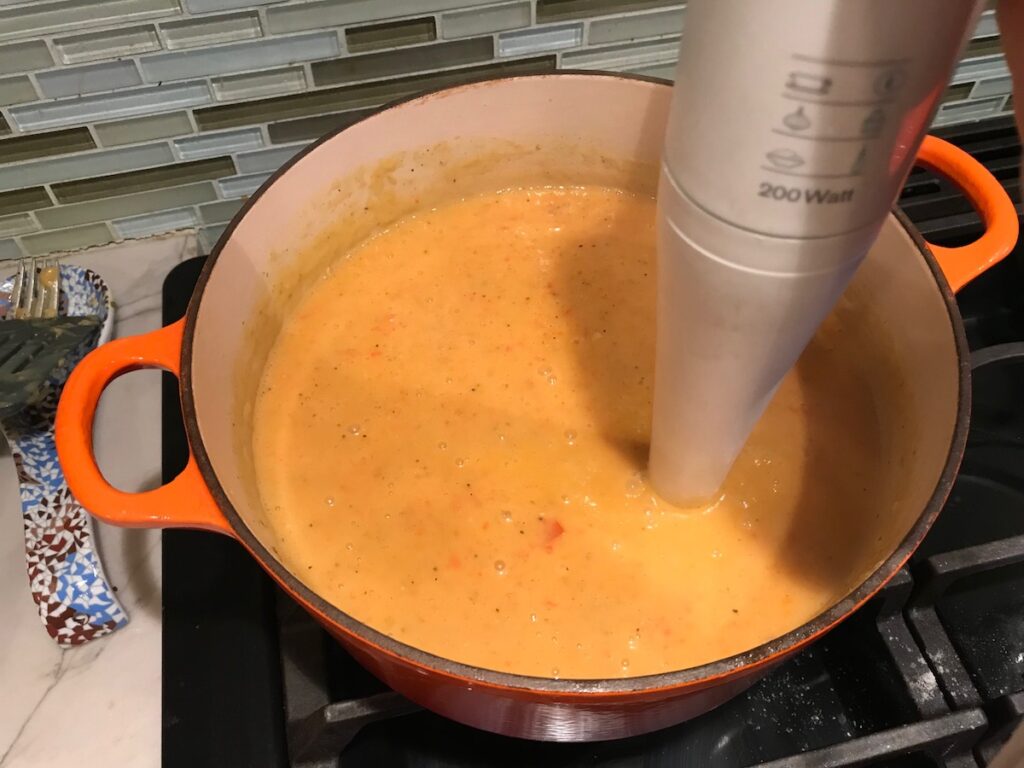 Immersion blender blending soup in pot for Red Pepper and Lentil Soup. This is an easy and hearty lunch or dinner!  It comes together in just 40 minutes.