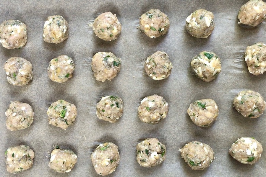 Raw chicken meatballs on a pan to show options for storing chicken.