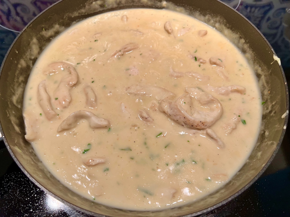 Sauce added to chicken and thickened in frying pan for White Sauce Chicken Pasta recipe.