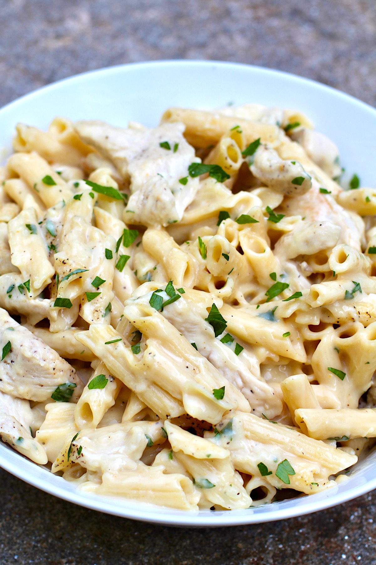 This image shows White Sauce Chicken Pasta served in a white bowl.