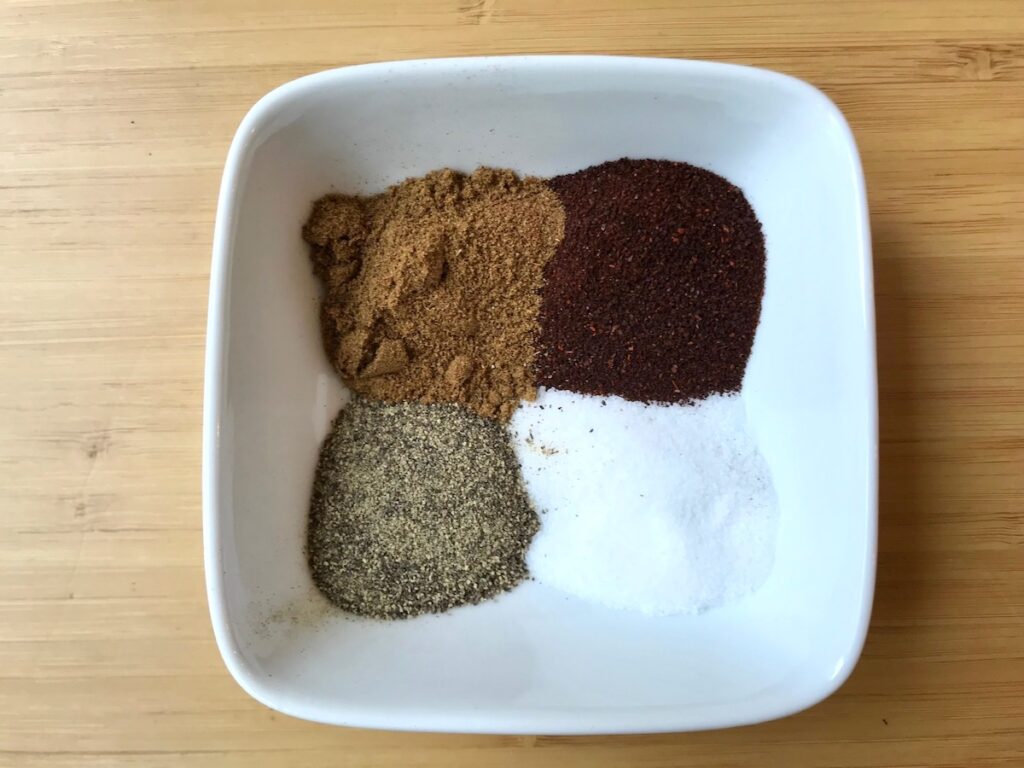Bowl of seasonings, cumin, chili powder, salt, pepper for Chipotle Chicken Pasta Recipe.