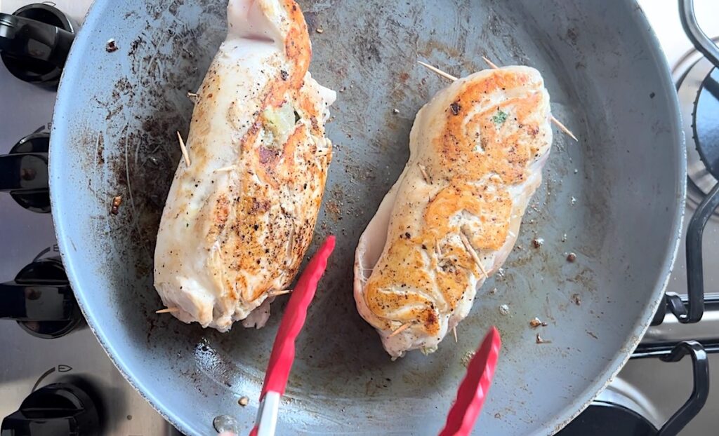 Chicken breast rolls searing in a skillet for Stuffing Stuffed Chicken Breast Recipes.