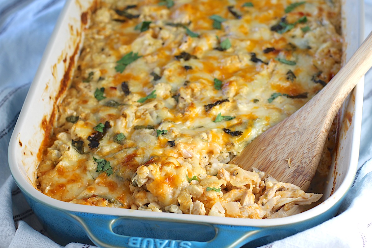 Low carb Cauliflower Rice and Chicken Casserole in a casserole dish with a spatula scooping it in the corner.