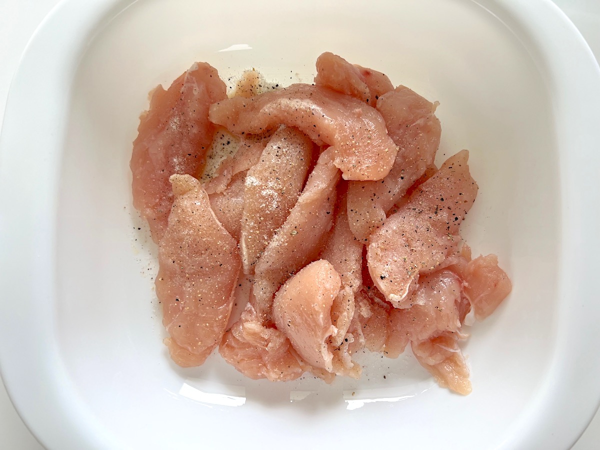 Raw Chicken at the bottom of a casserole dishfor the Creamy Chicken Piccata Casserole recipe.