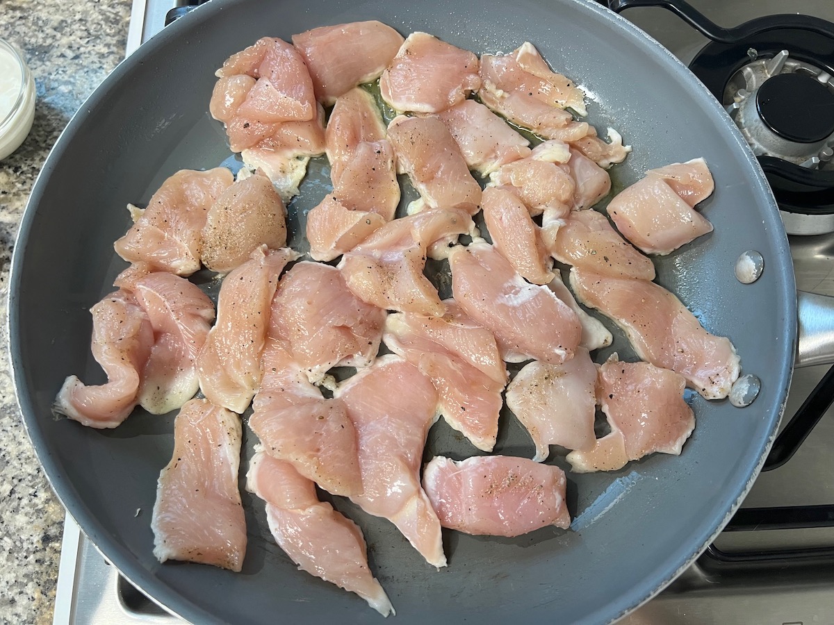 Raw chicken in a pan in a single layer for the Chicken and Vodka Pasta recipe.