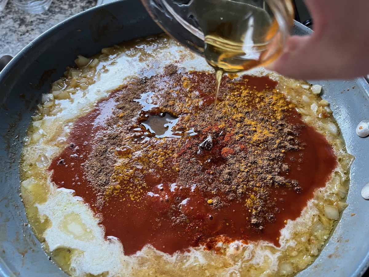 Honey being poured into the chicken broth mixture.