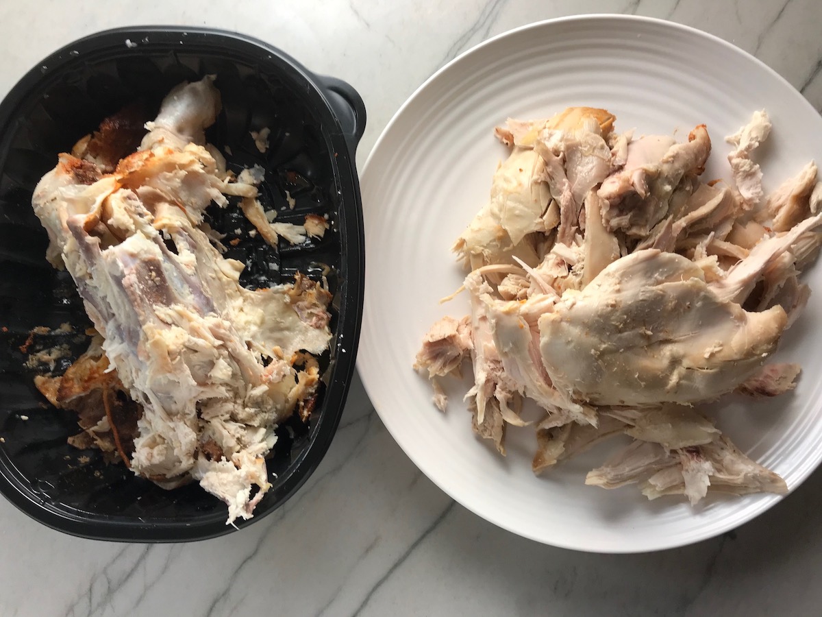 Cooked rotisserie chicken pulled from bones onto a plate on counter before shredded for Rotisserie Chicken Quesadillas recipe.