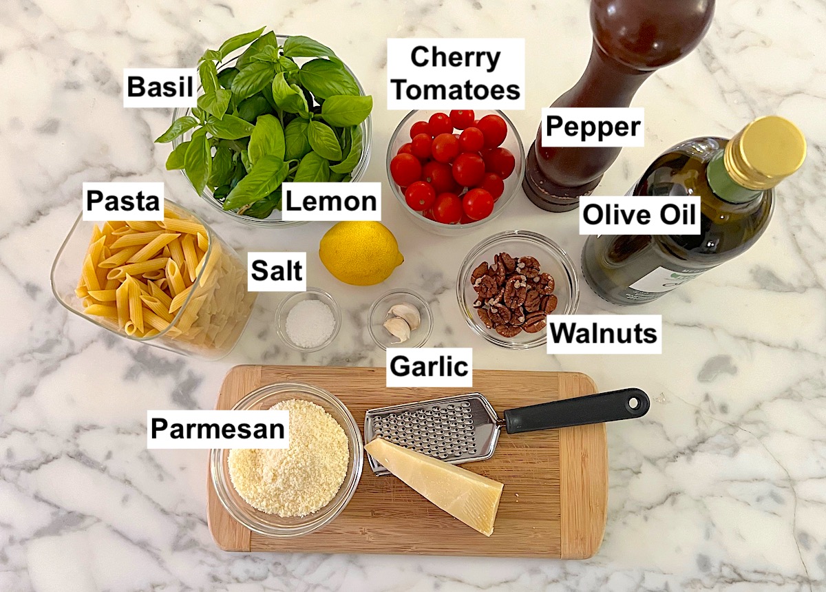 Ingredients prepped and measured out in small bowls, labeled on counter for Pesto Pasta with Tomatoes.