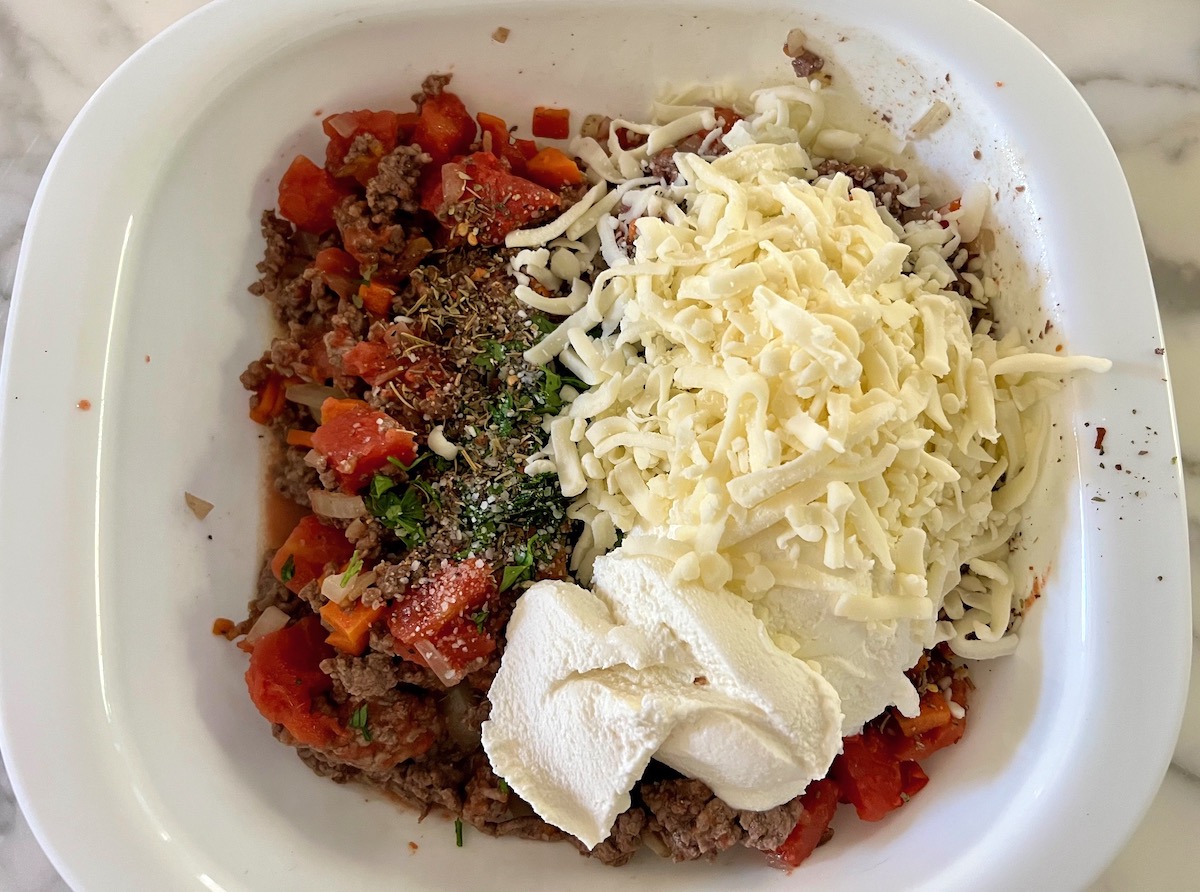 Ricotta cheese and shredded mozzarella added to casserole dish for Ground Beef and Zucchini Casserole recipe.