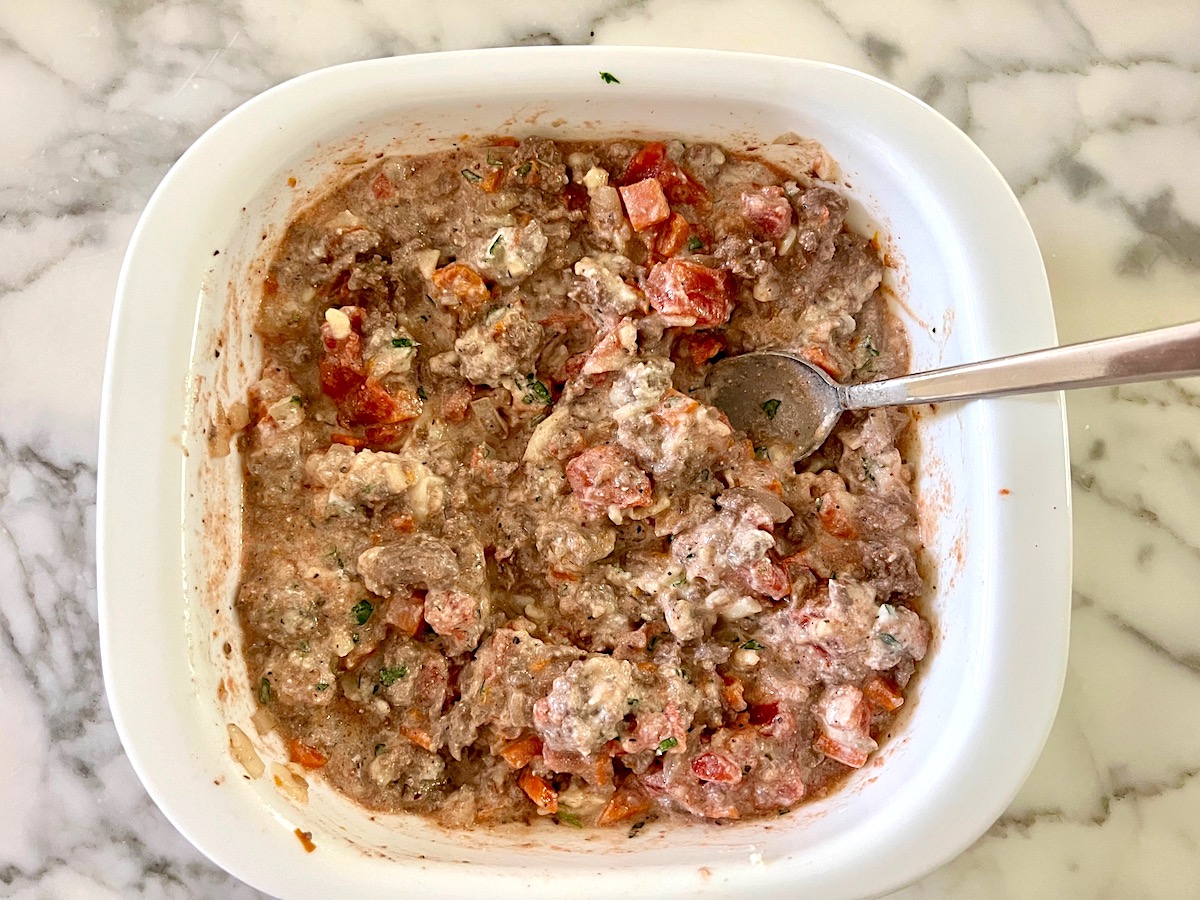 Beef and cheeses mixed in casserole dish for Ground Beef and Zucchini Casserole recipe.