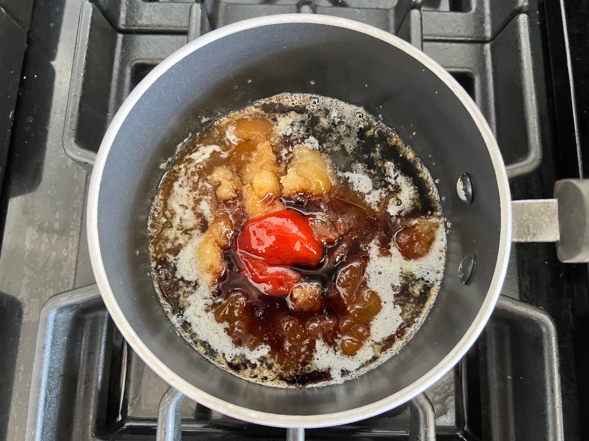 All ingredients in a saucepan on the stove before being mixed for the Apricot Sauce Wings recipe.