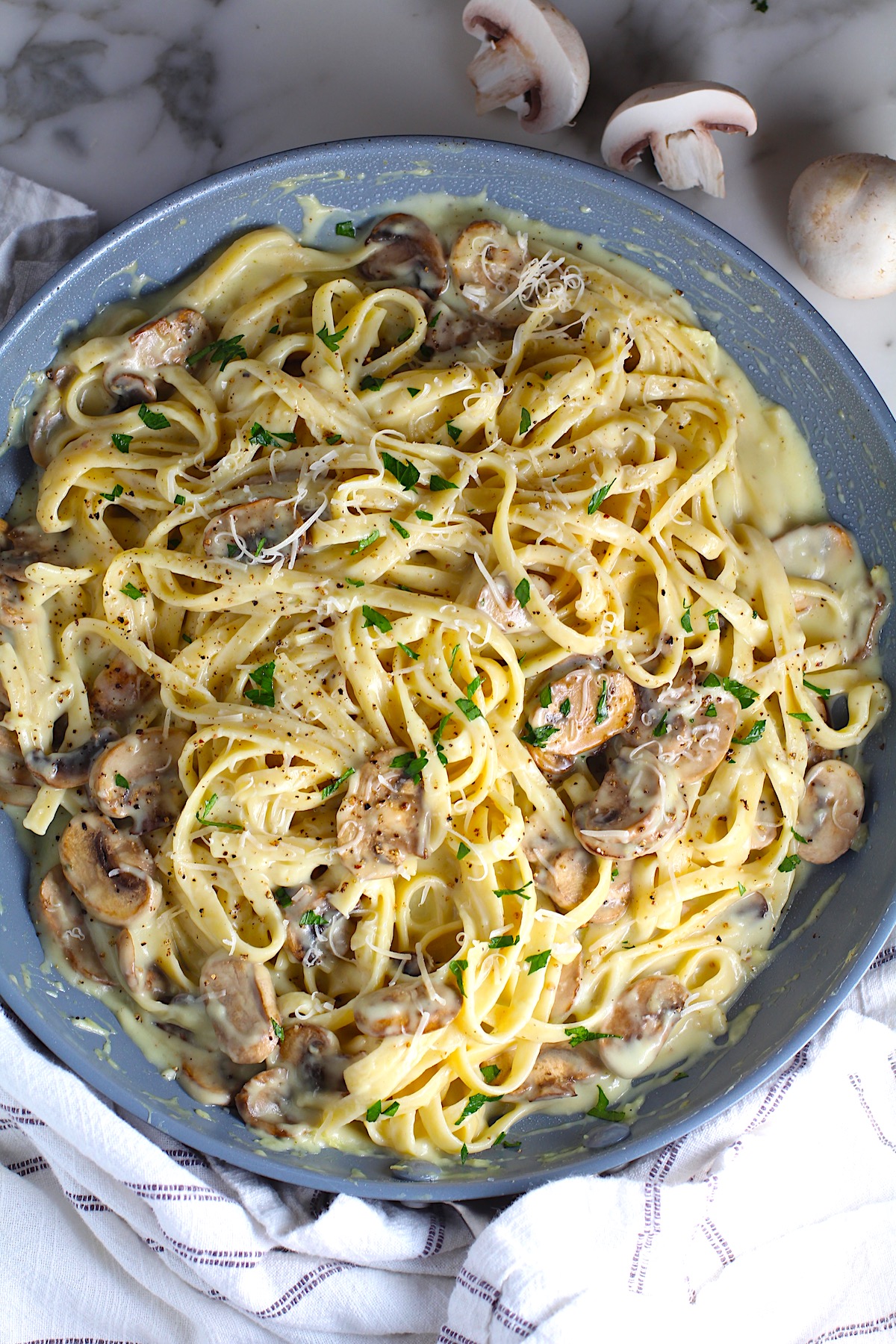 Mushroom Alfredo Fettuccine pasta in a pan with parsley sprinkled on top.