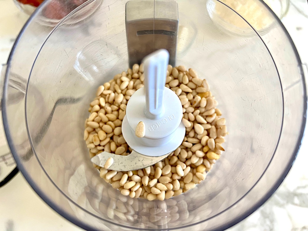 Pine nuts added to a food processor before being blended for Sun Dried Tomato Pesto Pasta.