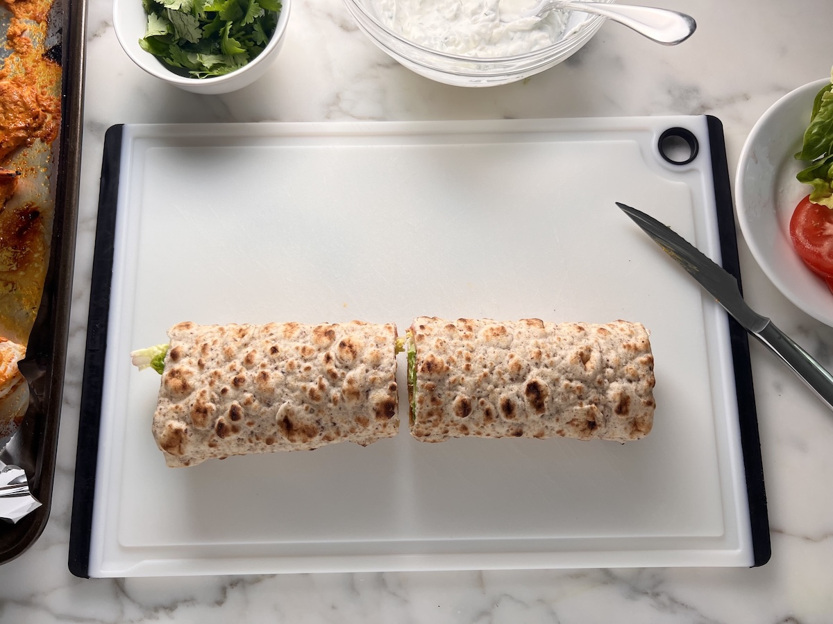 One large flatbread wrap stuffed and cut into two pieces for the Chicken Tikka Wraps recipe.