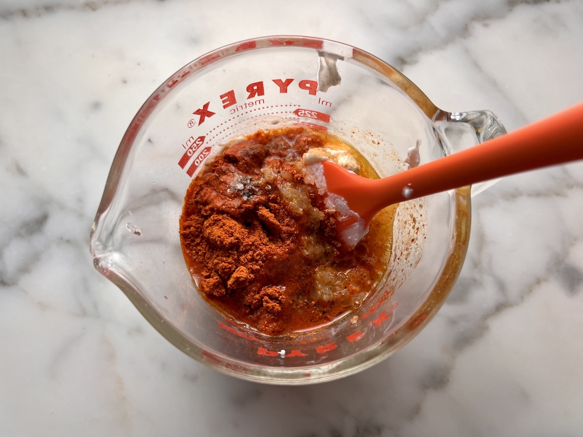 Tikka Seasoning, lemon juice, garlic, yogurt, and salt in a measuring cup with spatula before being mixed and added to marinate the chicken for the Chicken Tikka Wraps.