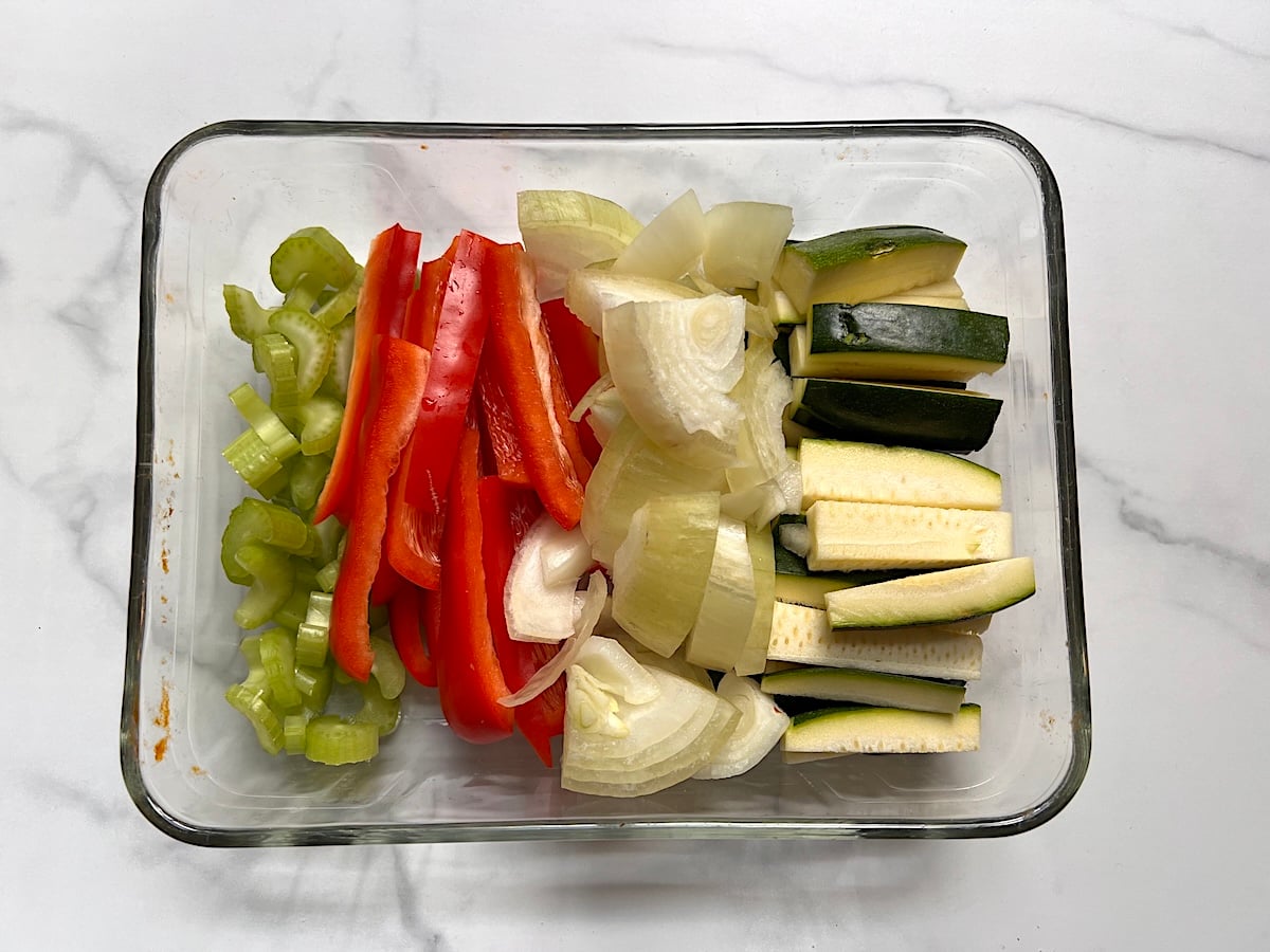 Sliced celery, red pepper, onions, and zucchini in a clear glass dish for this Chicken Stir Fry Recipe.