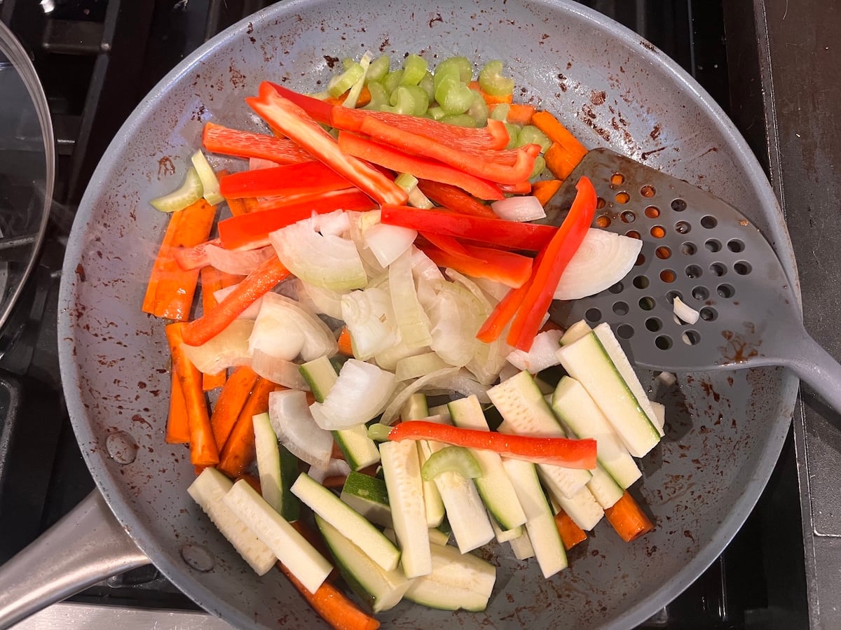Sliced zucchini, red pepper, celery, and onions added to carrots in the skillet for this Chicken Stir Fry Recipe.