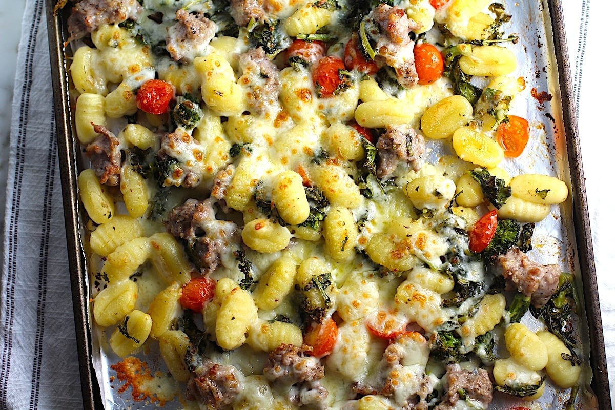 Sheet Pan Gnocchi, Italian Sausage, Broccoli Rabe, and Cherry Tomatoes golden brown with melted mozzarella on top.
