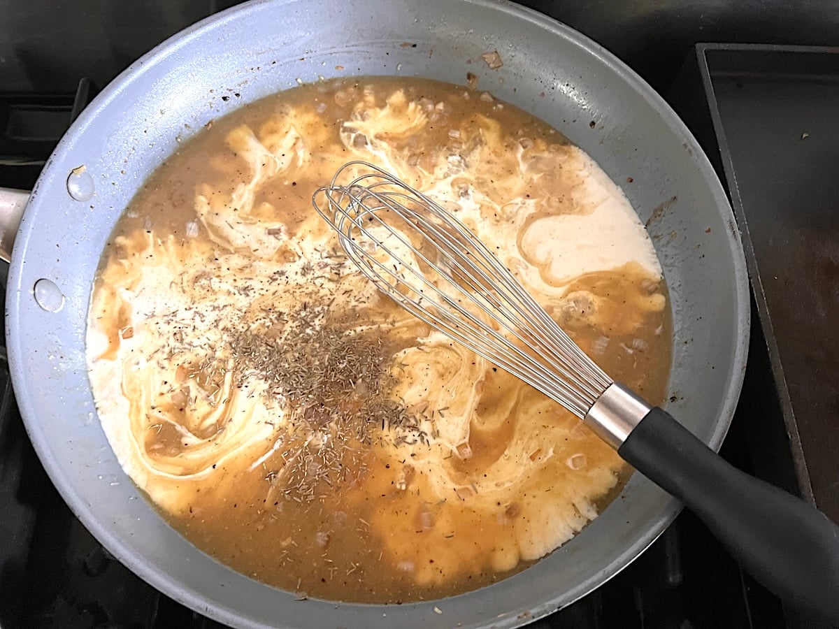 Whisking broth and cream or half and half to shallots and dijon in pan Finely diced shallots cooking and browning in the pan after the chicken is transferred out for the Chicken au Poivre recipe.