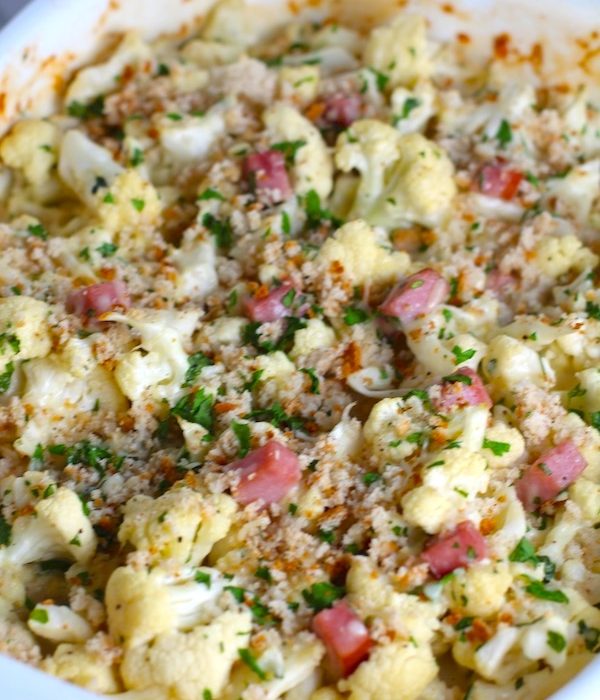 Close up of Gluten Free Cauliflower, Cheese and Ham Bake with parsley and breadcrumb topping. It layers in nutty and salty Gruyere Cheese, with a creamy Vegetable broth based sauce with garlic and parsley.  Then the ham and cauliflower are folded into all of this goodness and it's baked in the oven until it all becomes one knock-your-socks-off dish! #cauliflower #lowcarb #glutenfree #casserole #onepot #familydinner #mealprep #easydinner #dinner #healthydinner #healthyfood #healthyrecipes
