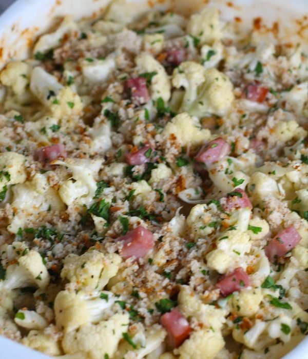 Close up of Cauliflower Cordon Bleu Bake with parsley and breadcrumb topping. It layers in nutty and salty Gruyere Cheese, with a creamy Vegetable broth based sauce with garlic and parsley.  Then the ham and cauliflower are folded into all of this goodness and it's baked in the oven until it all becomes one knock-your-socks-off dish! #cauliflower #lowcarb #glutenfree #casserole #onepot #familydinner #mealprep #easydinner #dinner #healthydinner #healthyfood #healthyrecipes
