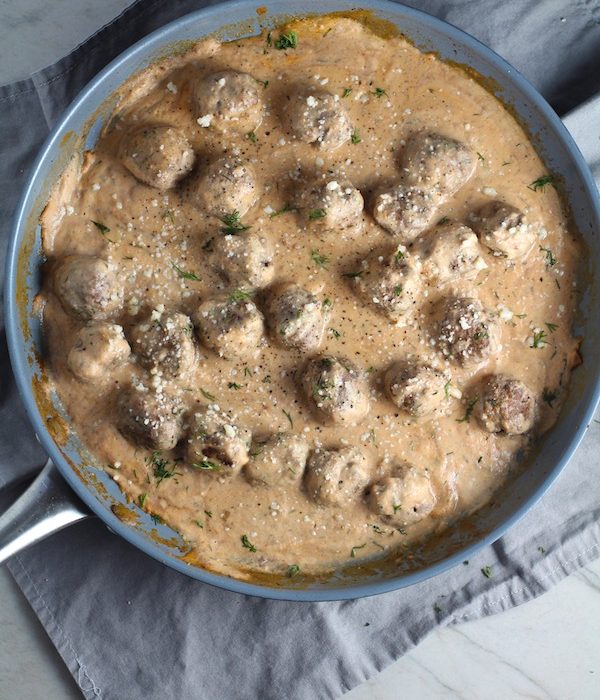 Meatballs in Cauliflower Dill Cream Sauce in a skillet. The Meatballs are swimming in a beautiful creamy cauliflower sauce flavored with garlic, fresh dill, cream cheese, and a touch of tomato paste. #meatballs #swedishmeatballs #familydinner #easydinner #dinner #healthydinner