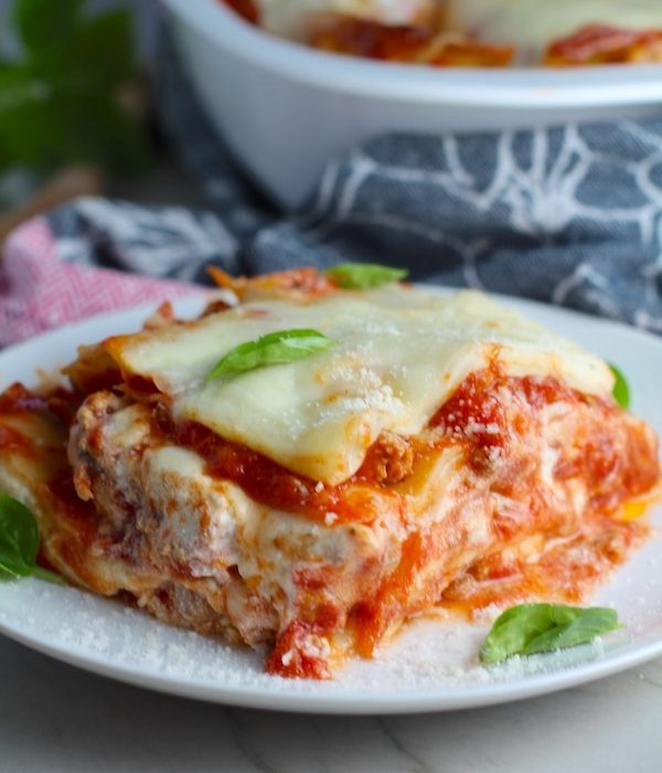 Chicken Lasagna on a plate with fresh basil. from the dish. This Italian Sausage Lasagne Recipe is the stuff that dreams are made of.  Layers of pasta, creamy ricotta, salty chewy mozzarella, salty and hearty Italian Sausage, and sweet and tangy tomato sauce.
