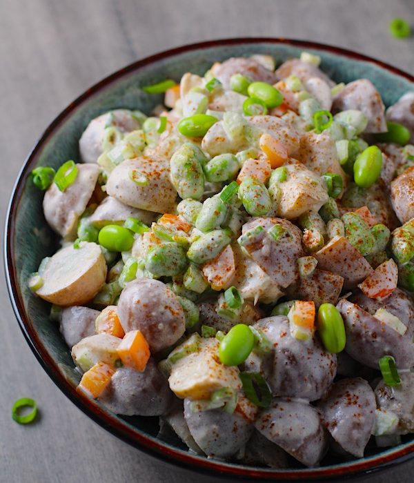 Red Skin Potato Salad Recipe with Edamame and Harissa in a bowl on table. It's creamy, crunchy, meaty, tangy, peppery, salty, and oh, it's UNBELIEVABLE!
