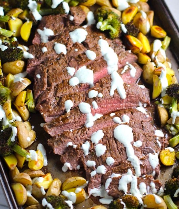 Flank Steak sliced with Potatoes & Broccoli on sheet pan with crema drizzled on top. This is an easy and delicious Sheet Pan Dinner.  The homemade steak rub adds such wonderful flavor. To top this sheet pan dinner, you get this tangy, light Garlic Chive Crema!  Best of all, you only need 1 pan so it's a super easy clean up.  Easy and Delicious!