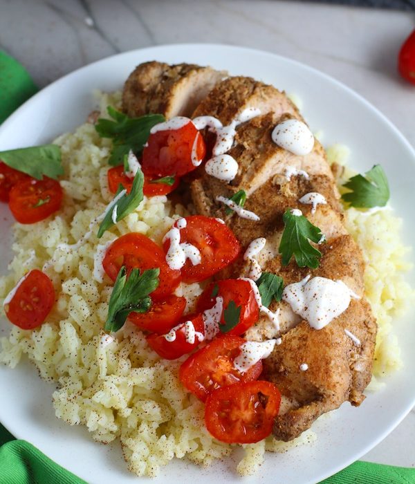 Sliced Mexican Chicken on rice with tomatoes, sour cream, & cilantro. This marinade is an easy, make-ahead, and delicious recipe! The chicken is infused with so much smokey, savory flavors from the fresh garlic, chili powder, and cumin.  #marinade #chicken #easydinners