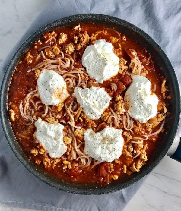 This Skillet Chicken Tomato Sauce with Ricotta is a delicious and simple one pan meal.  Ground chicken is seared until it gets a super browned, flavorful crust.  Then garlic, vegetable broth and tomatoes are added and cooked down into a delightful sauce that really lets the tomato shine with a meaty bite from the chicken.  After pasta is mixed in, creamy Ricotta Cheese is dolloped on and fresh basil added to garnish.  It's perfection! Bellissimo!