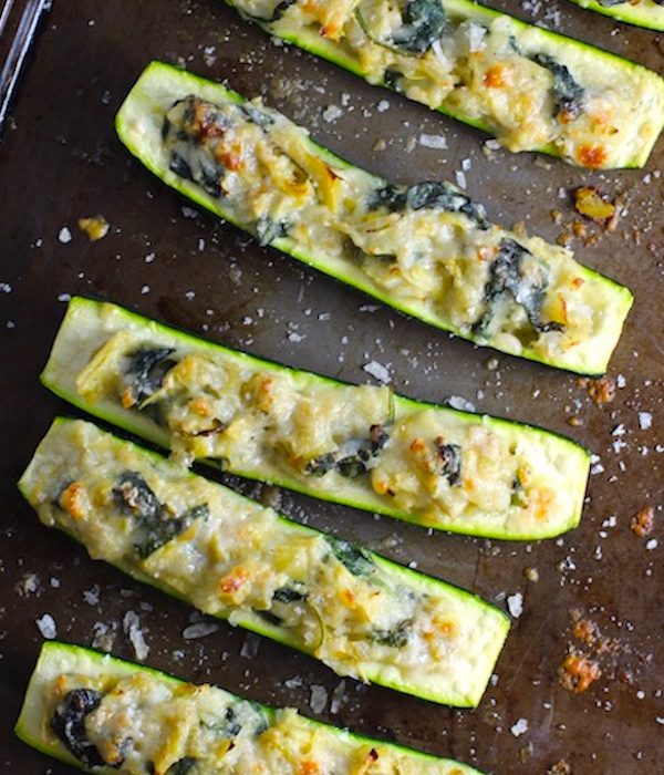 Artichoke Spinach Stuffed Zucchini Recipe on a pan. Each fantastic bite gives you creamy artichoke, nutty cheesy Parmesan, spinach, and zucchini. Prepare entirely ahead, then bake 20 minutes and enjoy! #vegetarian #zucchini #stuffedzucchini #spinach #artichoke #springrecipes #healthyfood #healthydinner #healthyrecipes #glutenfree