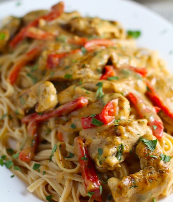Creamy Tarragon Mustard Sauce with Chicken and Red Peppers over pasta on a plate. It's creamy, tangy, savory, and so addictive.  It gets so much flavor from dijon mustard, tarragon, garlic, and onion. It's an easy-to-whip-up any night dinner! #easydinners